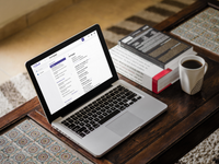 Een laptop staat op tafel met daarop een schermafbeelding van het 'Van Dale Financieel-economisch lexicon NL-EN/EN-NL'