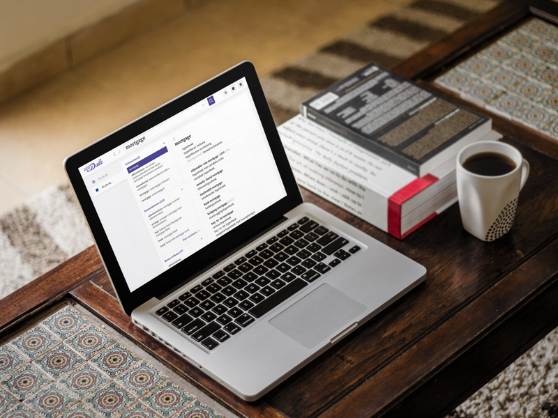 Een laptop staat op tafel met daarop een schermafbeelding van het 'Van Dale Financieel-economisch lexicon NL-EN/EN-NL'